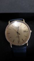 A Longines watch with gold face and stainless steel back, date in face - working in the saleroom