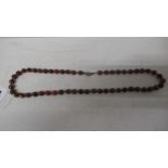 An amber bead necklace - 62cm - with a silver clasp