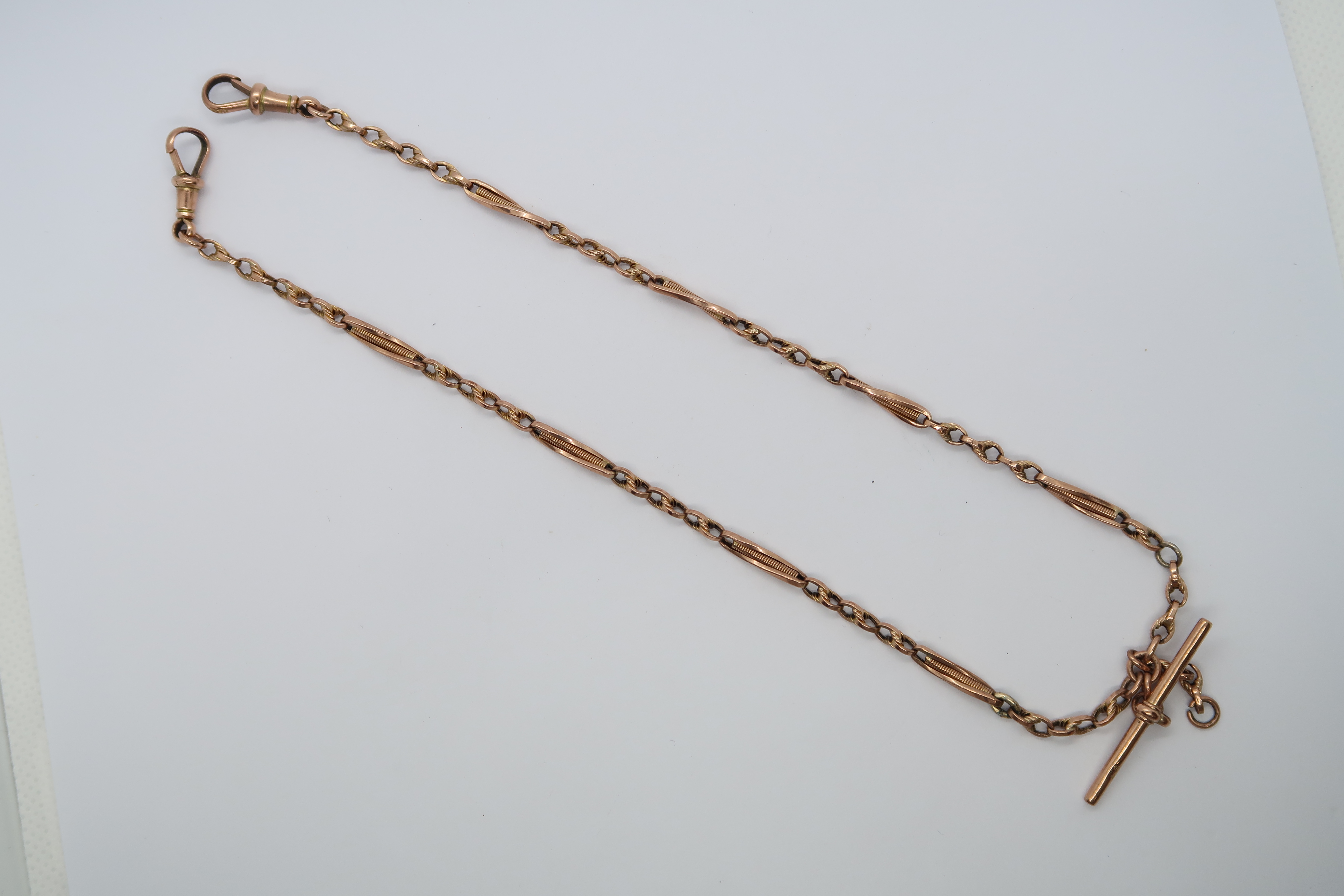 A hallmarked 9ct red gold watch chain with T-bar, 37cm long, approx 9 grams