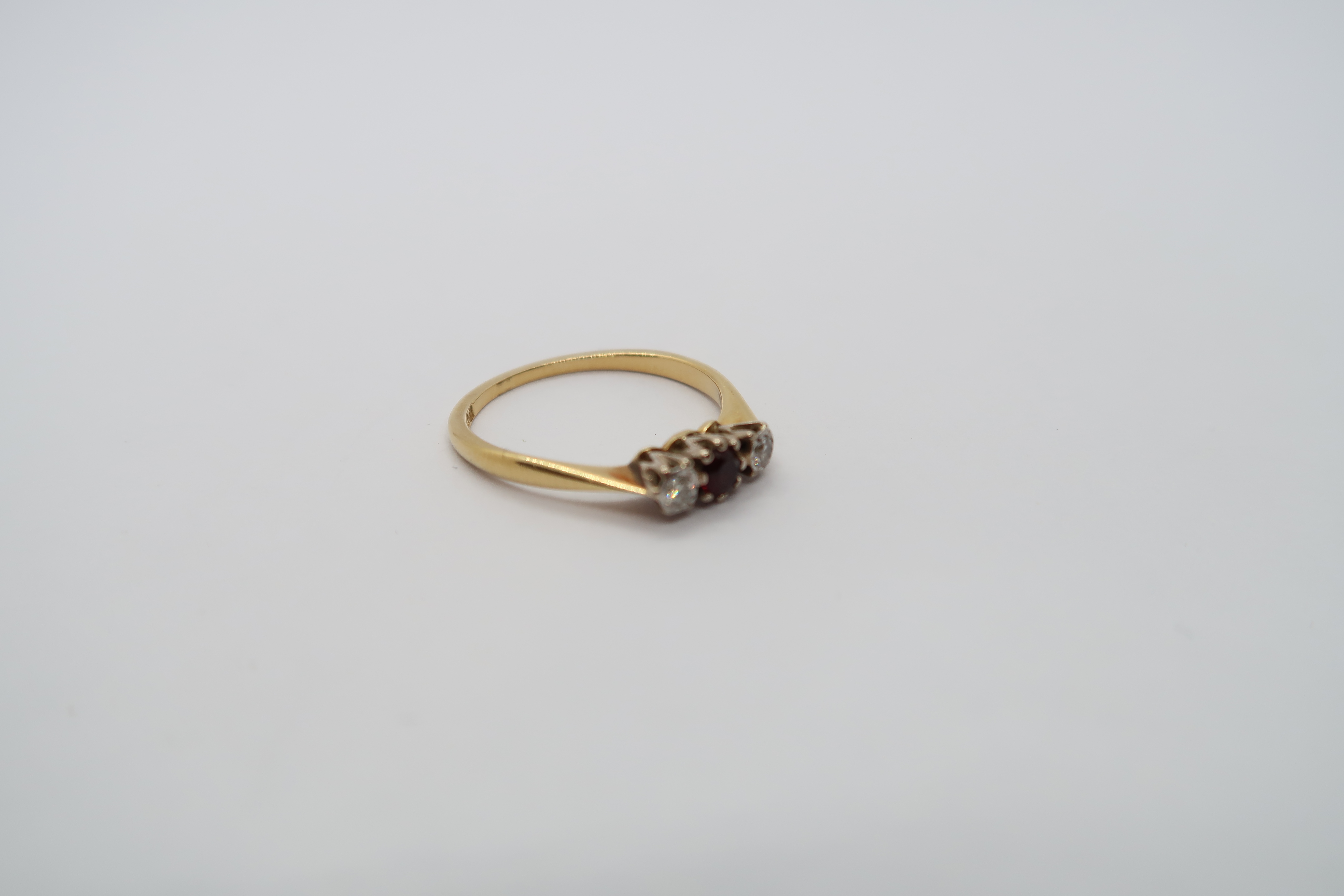 An 18ct hallmarked yellow gold three stone ring with diamonds and garnet, size L, approx 2 grams - Image 2 of 3