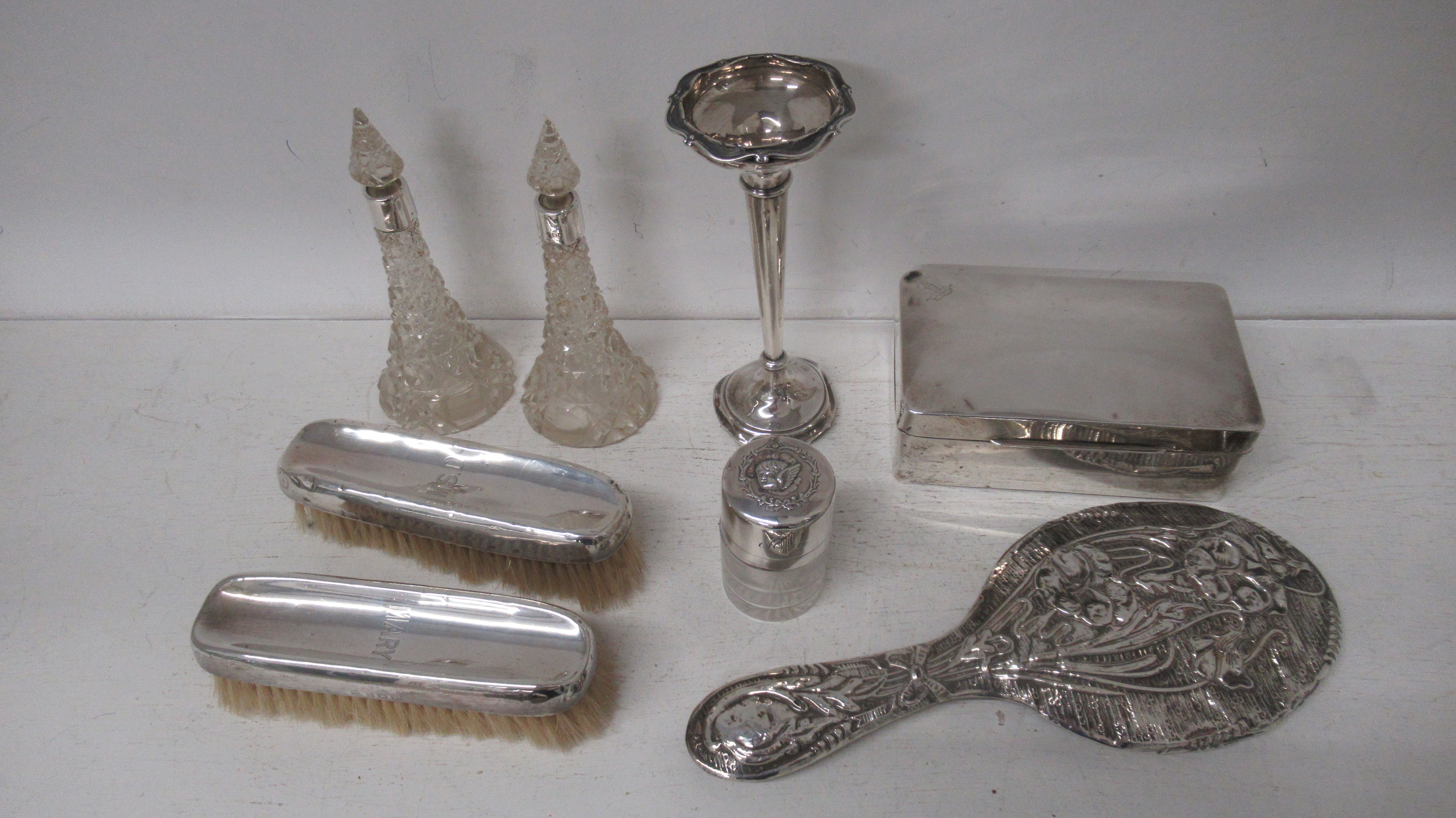 Assorted silver items including cigarette box, two brushes, mirror, posey vase, three glass bottles