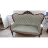 A mahogany framed settee with a buttoned back, nicely upholstered and in good condition