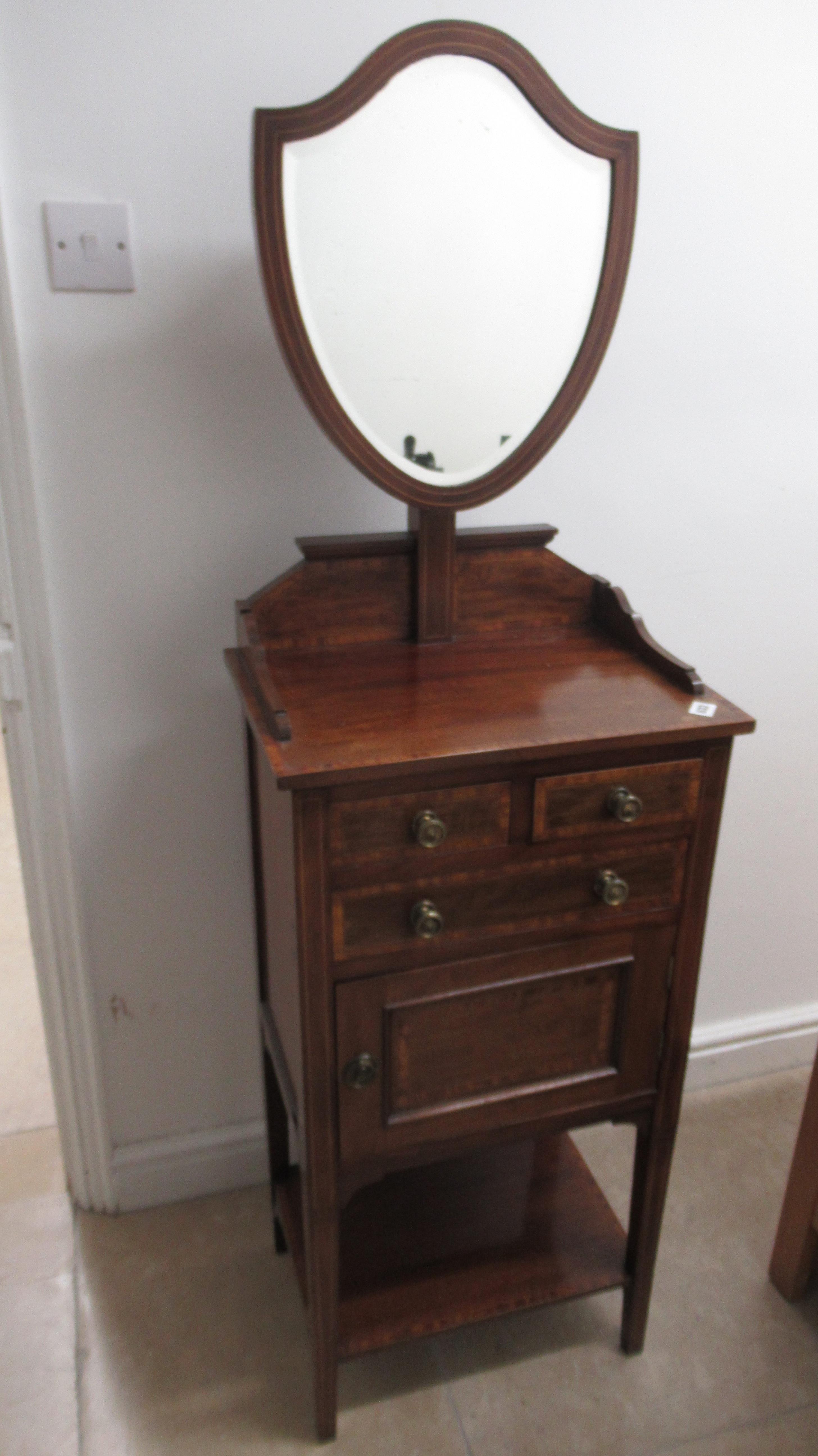 A late Victorian shaving stand with a mirror above drawers and a cupboard door in good condition -