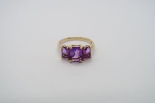 A 9ct yellow gold three stone amethyst ring, amethysts are a good colour and well matched, head size