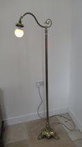 A tall 20th century brass standard lamp - missing its shade, in working order