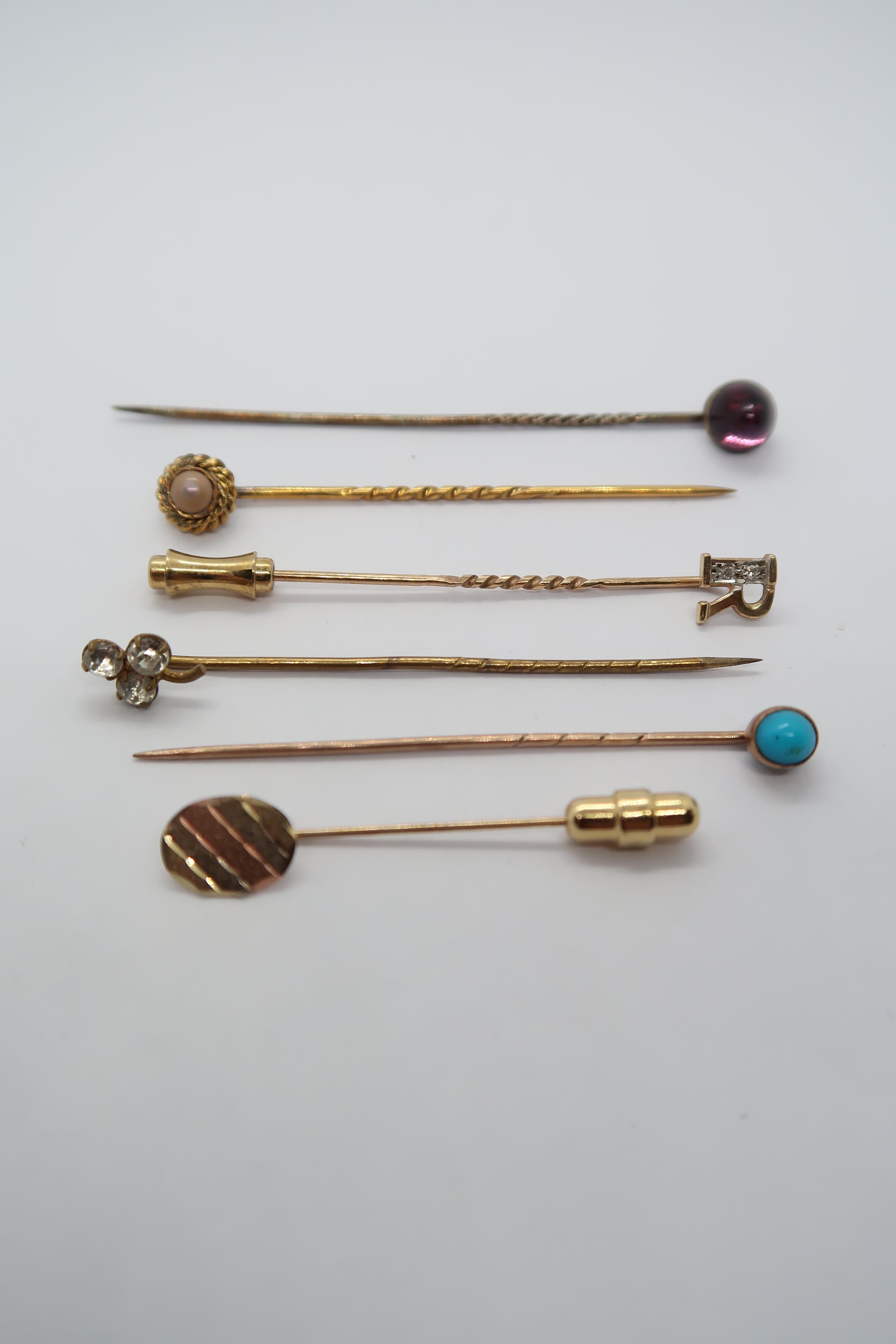 Four gold tie pins, 3.8 grams with one silver and one other