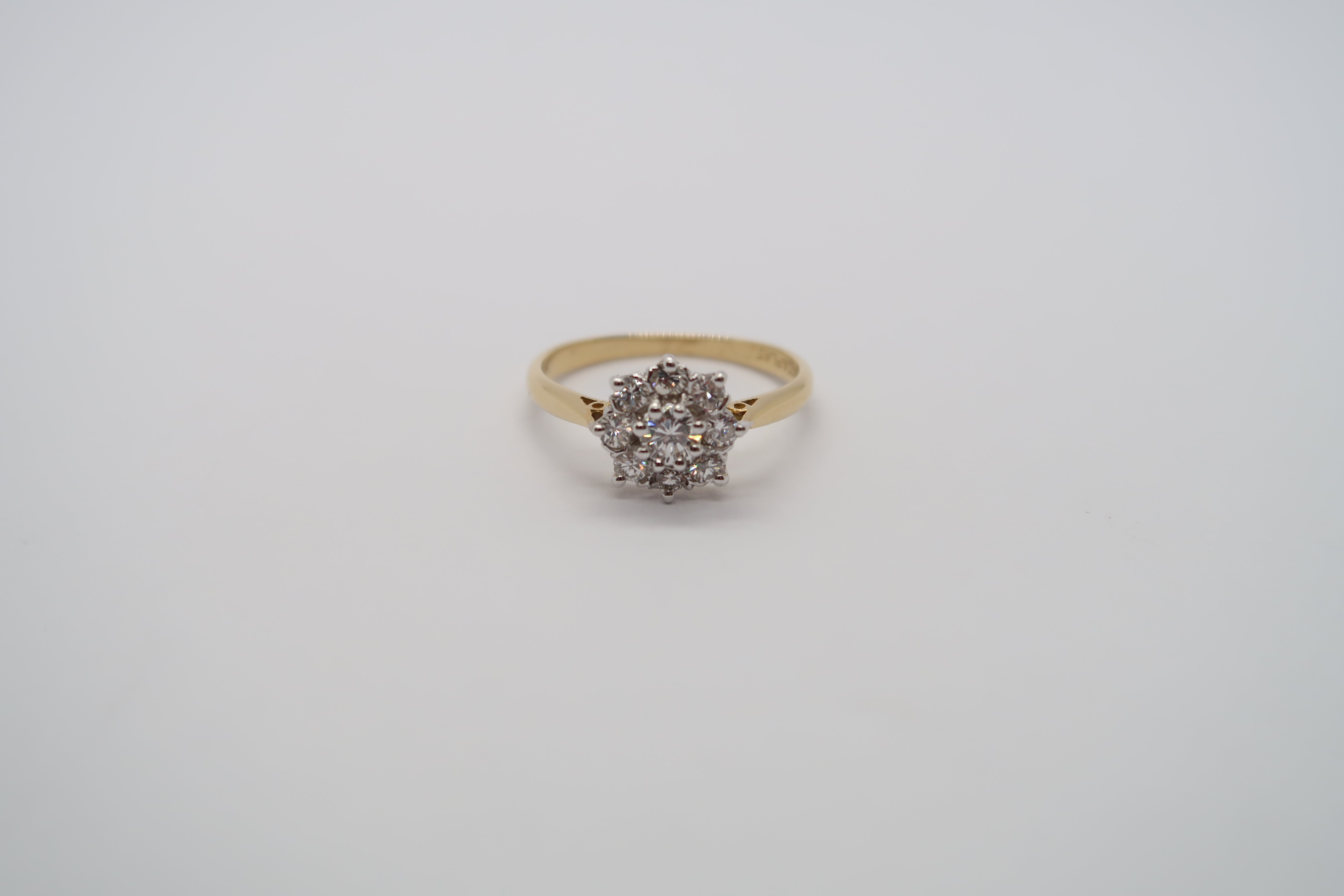 A good quality 18ct yellow gold and platinum 9 stone diamond cluster ring, diamonds are well