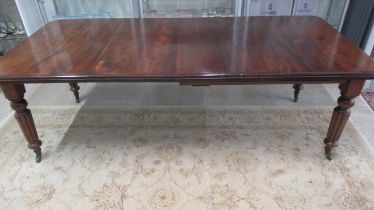 A 19th century mahogany dining table with two leaves on reeded legs - Length 220cm x Width 103cm -