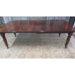A 19th century mahogany dining table with two leaves on reeded legs - Length 220cm x Width 103cm -