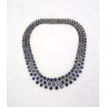 A stunning three row articulated sapphire and diamond necklace. The graduating circular claw set