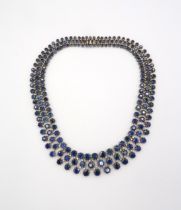A stunning three row articulated sapphire and diamond necklace. The graduating circular claw set