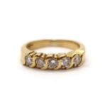 A diamond eternity ring in yellow colour metal, part hoop, comprising of five round brilliant cut