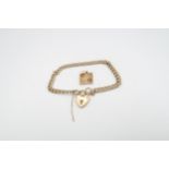 A 9ct yellow gold bracelet with heart lock and floral panel, 9.5cm diameter, approx 10 grams