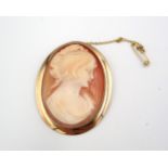 A probably 9ct yellow gold mounted cameo brooch of oval form - approx 6cm x 4cm