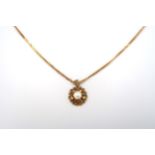 A 9ct gold circular panel openwork pendant, set with a 5.8mm cultured pearl. Suspended from a