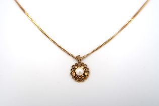 A 9ct gold circular panel openwork pendant, set with a 5.8mm cultured pearl. Suspended from a