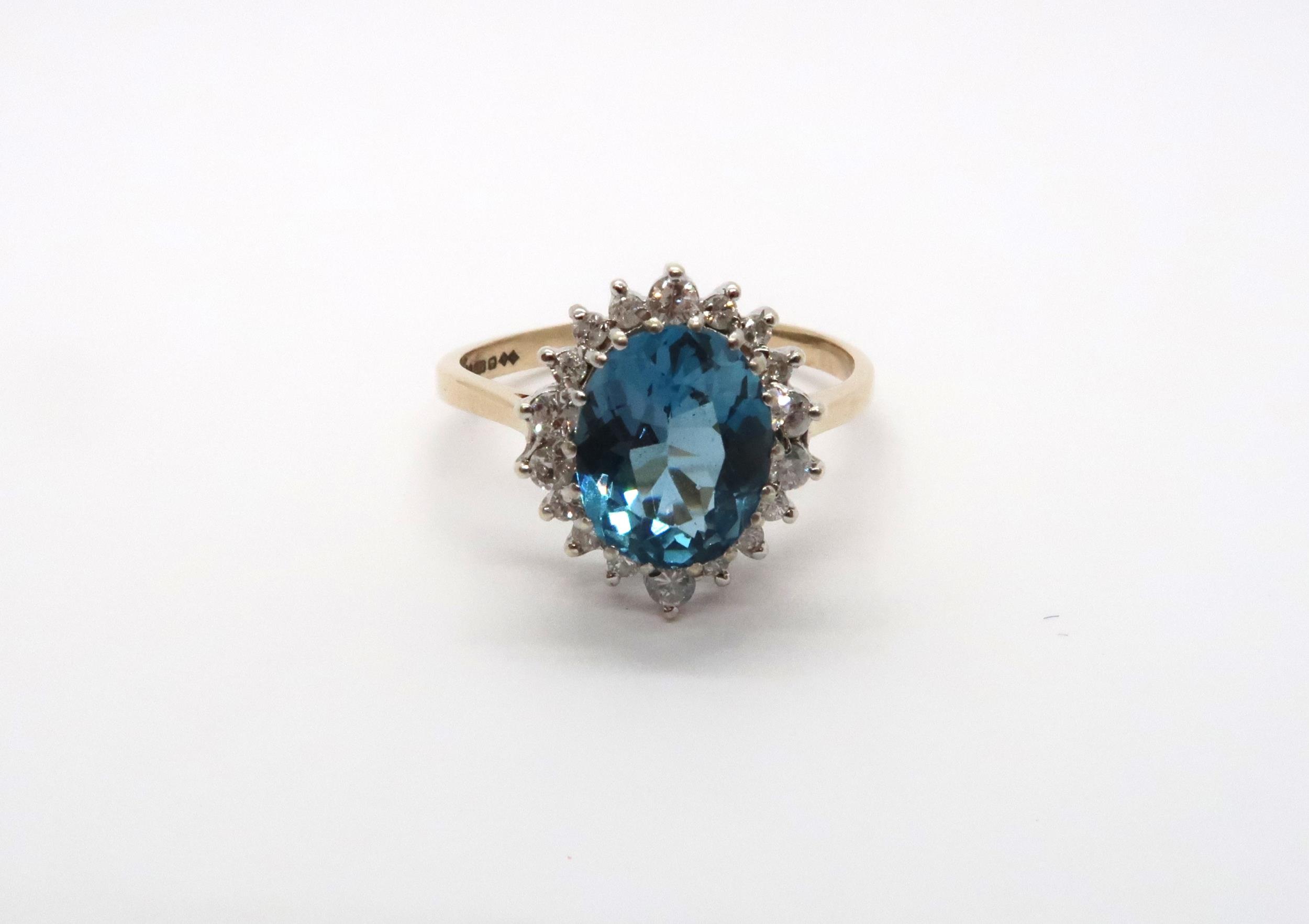 A 9ct yellow gold blue topaz and diamond ring, topaz is a good colour, diamonds bright and lively,