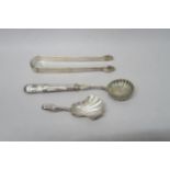 A hallmarked silver strainer and sugar nips - approx weight 2.08 troy oz - and a silver spoon - 0.23