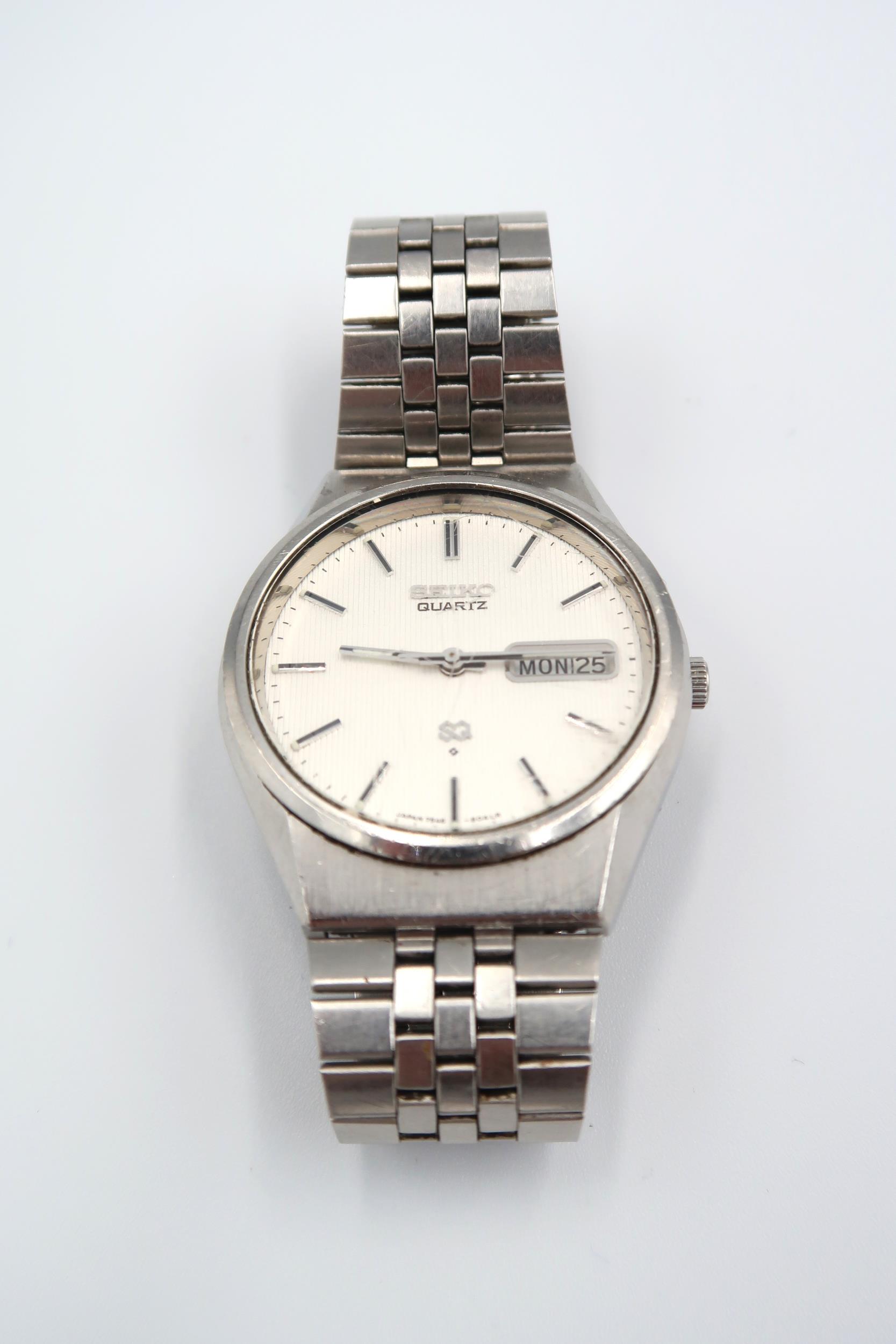 A Seiko gents watch with baton markers, day date aperture at 3 o'clock