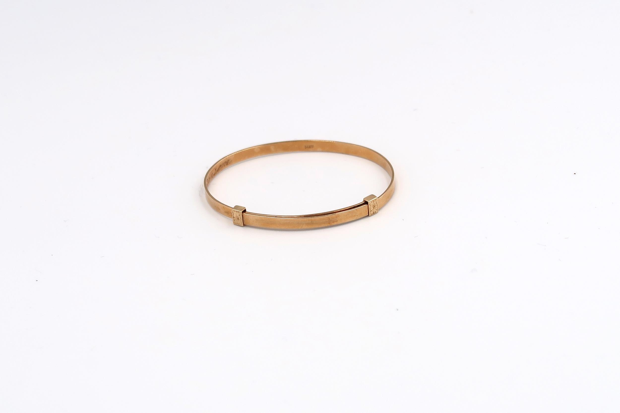 A child's adjustable bangle. Stamped 14K. Weight 4.29 grams.