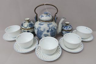 A blue and white Oriental teapot with yellow metal handle decorated with figures amongst prunus, six