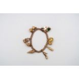 A 9ct gold charm bracelet - approx weight 27.5 grams - ten charms
