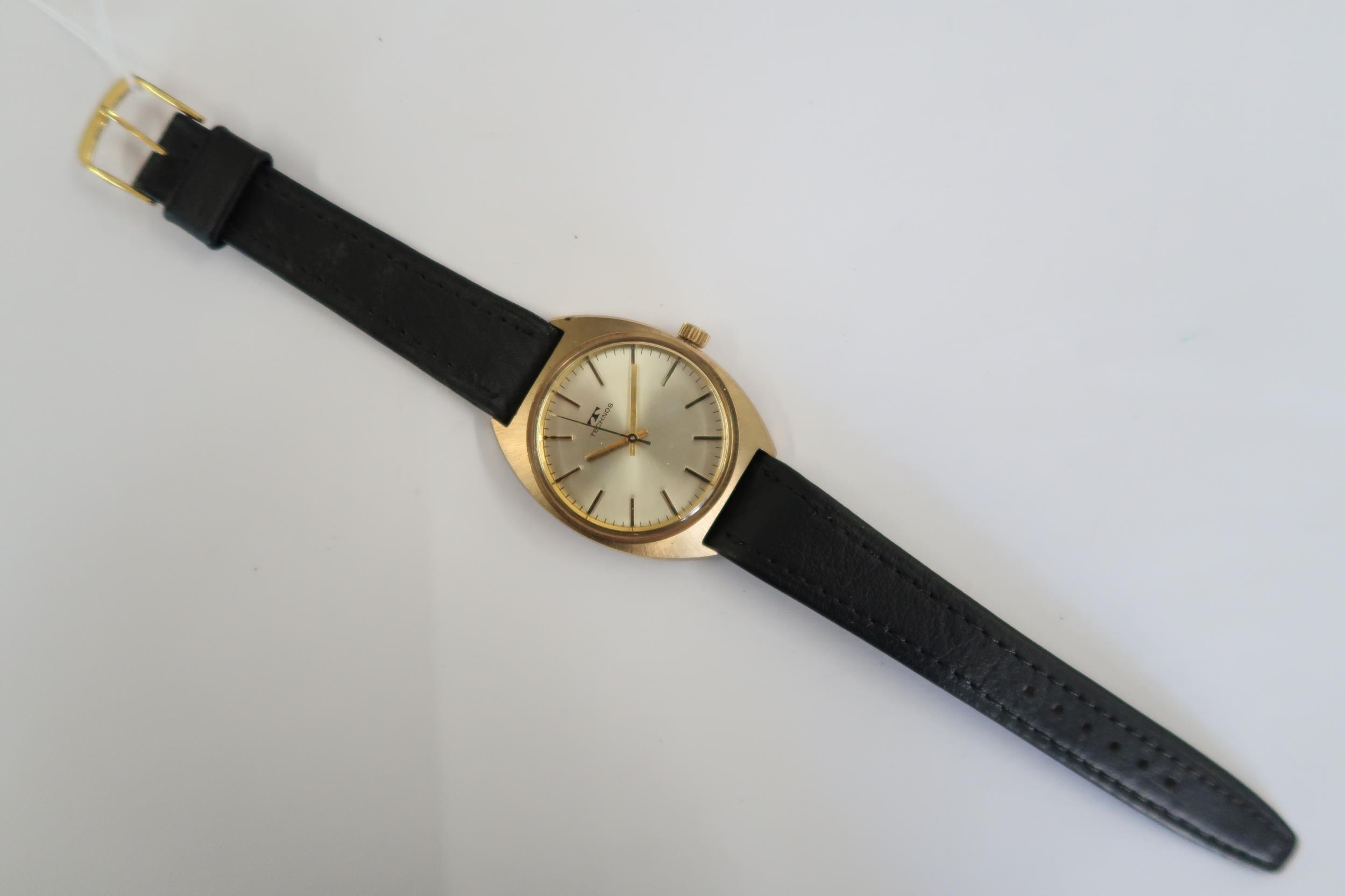 A Gents Technos automatic watch with gold face on a black leather strap, running in saleroom - Image 3 of 3