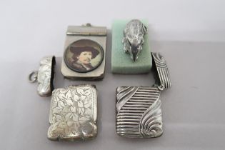 Three white metal vestas, one engraved with foliate field and central reserve, one with ribbed