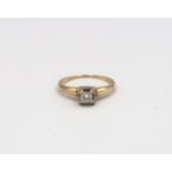 An illusion set 14ct yellow gold and diamond solitaire ring with chip - ring size M - 1.9 grams