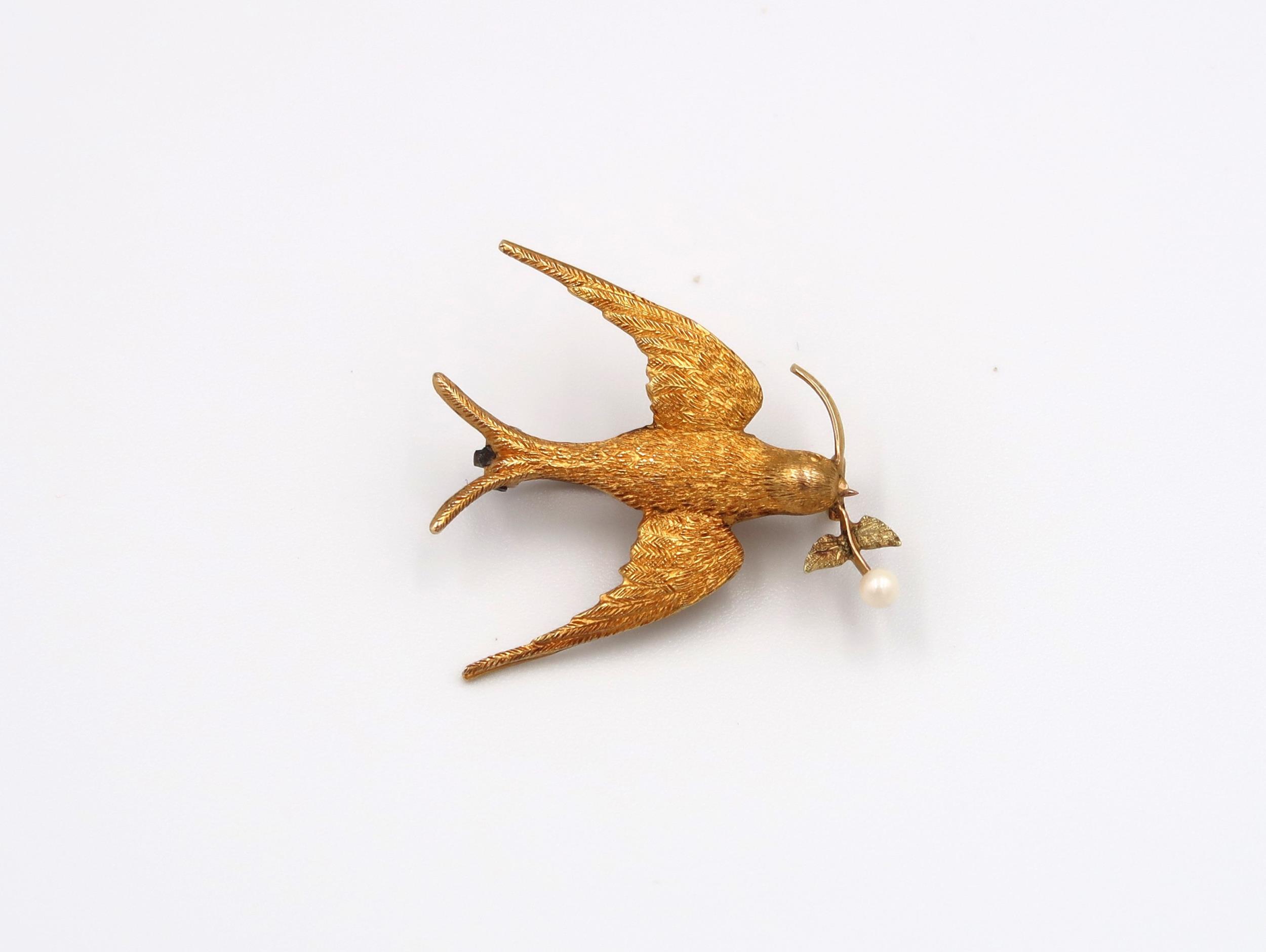 A marked .625ct yellow gold brooch in the form of a swallow with 15ct olive branch, approx 2.26
