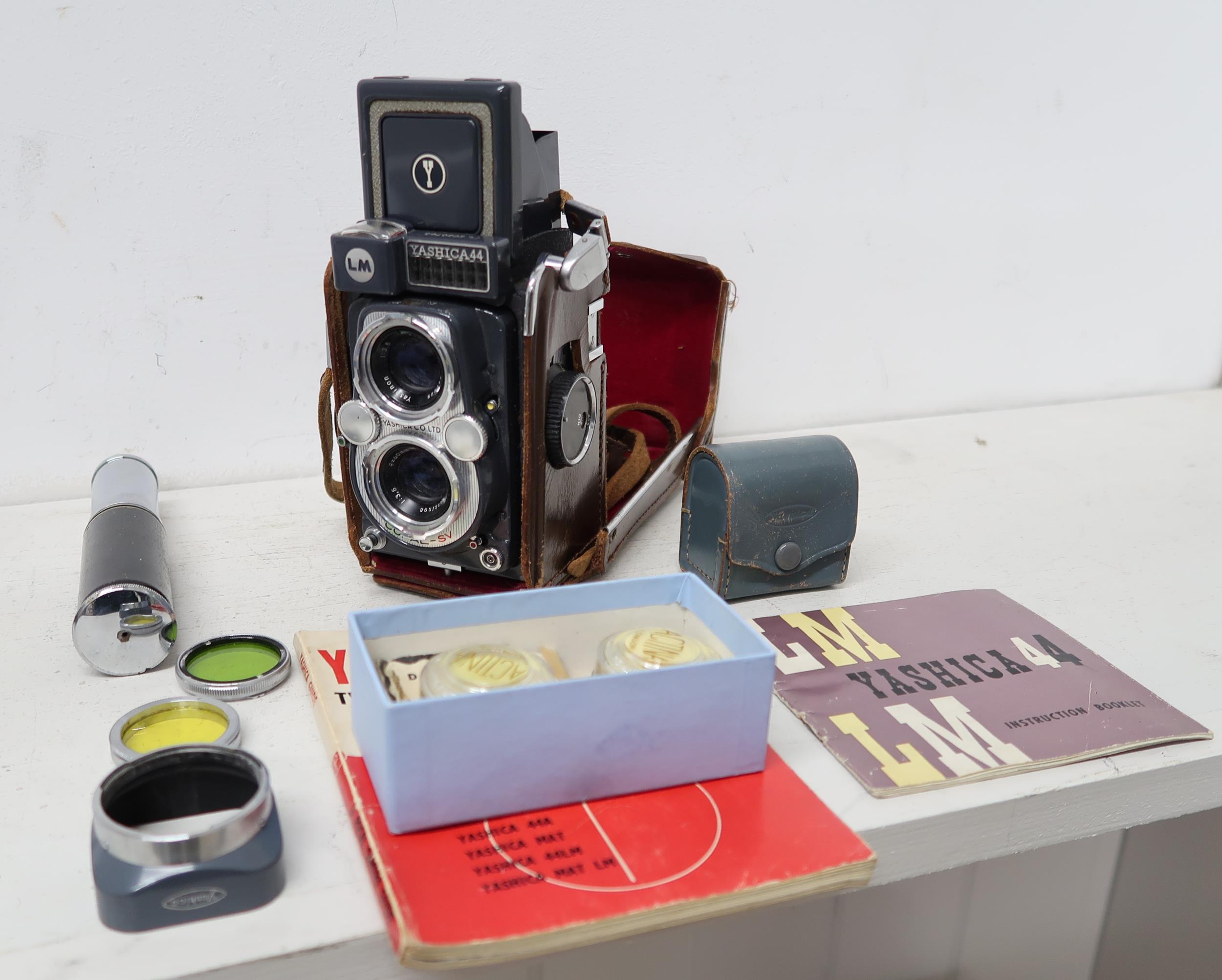 A Yashica 44 camera and assorted lens, booklets etc
