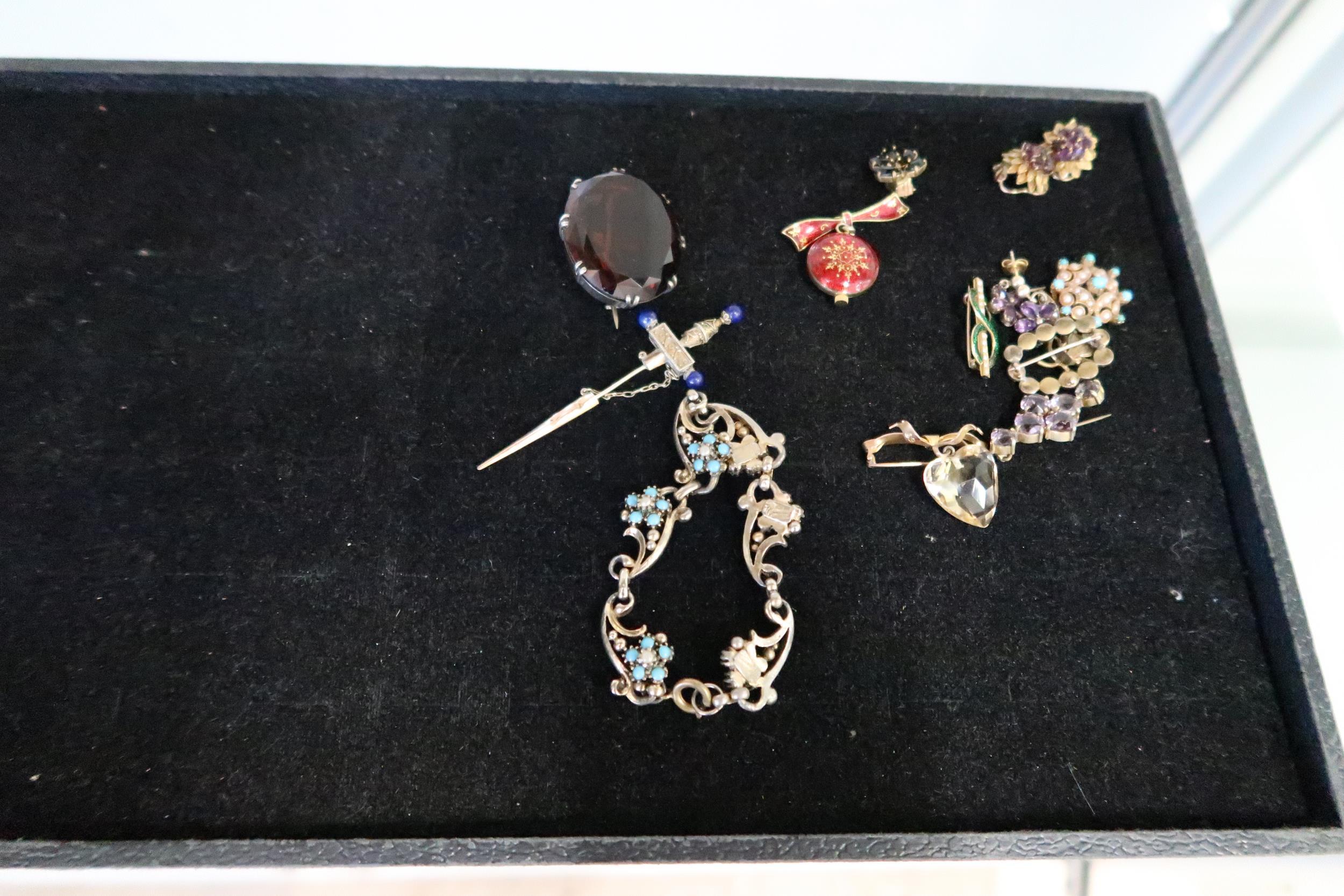 An assortment of items to include: a white metal oval smokey quartz brooch; a bow brooch