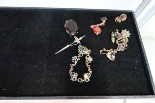 An assortment of items to include: a white metal oval smokey quartz brooch; a bow brooch