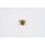 A 9ct gold sapphire and single cut diamond cluster ring with bark effect shoulders. Weight 3.49