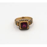 A garnet and enamel ring believed to be 19th century. Tested gold 18ct. Weight 6.47 grams. Ring size