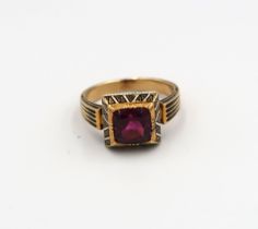 A garnet and enamel ring believed to be 19th century. Tested gold 18ct. Weight 6.47 grams. Ring size