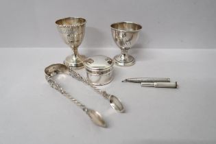 Two silver Christening egg cups, pill box and sugar nips along with a silver propelling pencil,