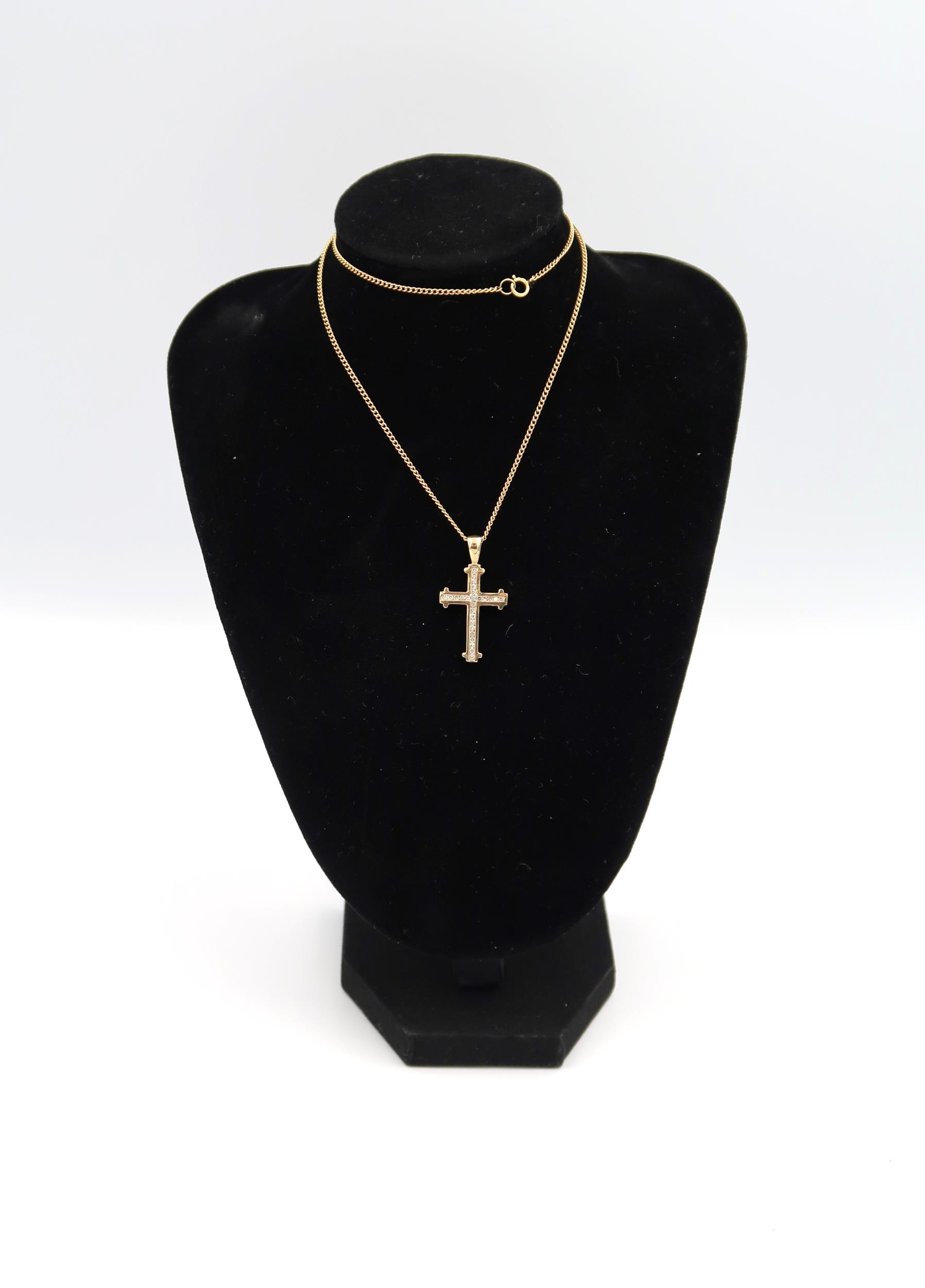 A 9ct yellow gold crucifix with 26 small cut diamonds on a 9ct gold chain, approx 5 grams