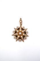 A seed pearl starburst pendant. Length 40mm. Width 30mm. Tests as approximately 15ct gold. Weight