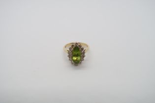 An 18ct yellow gold marquis cut peridot and diamond ring, peridot is good colour, diamonds bright