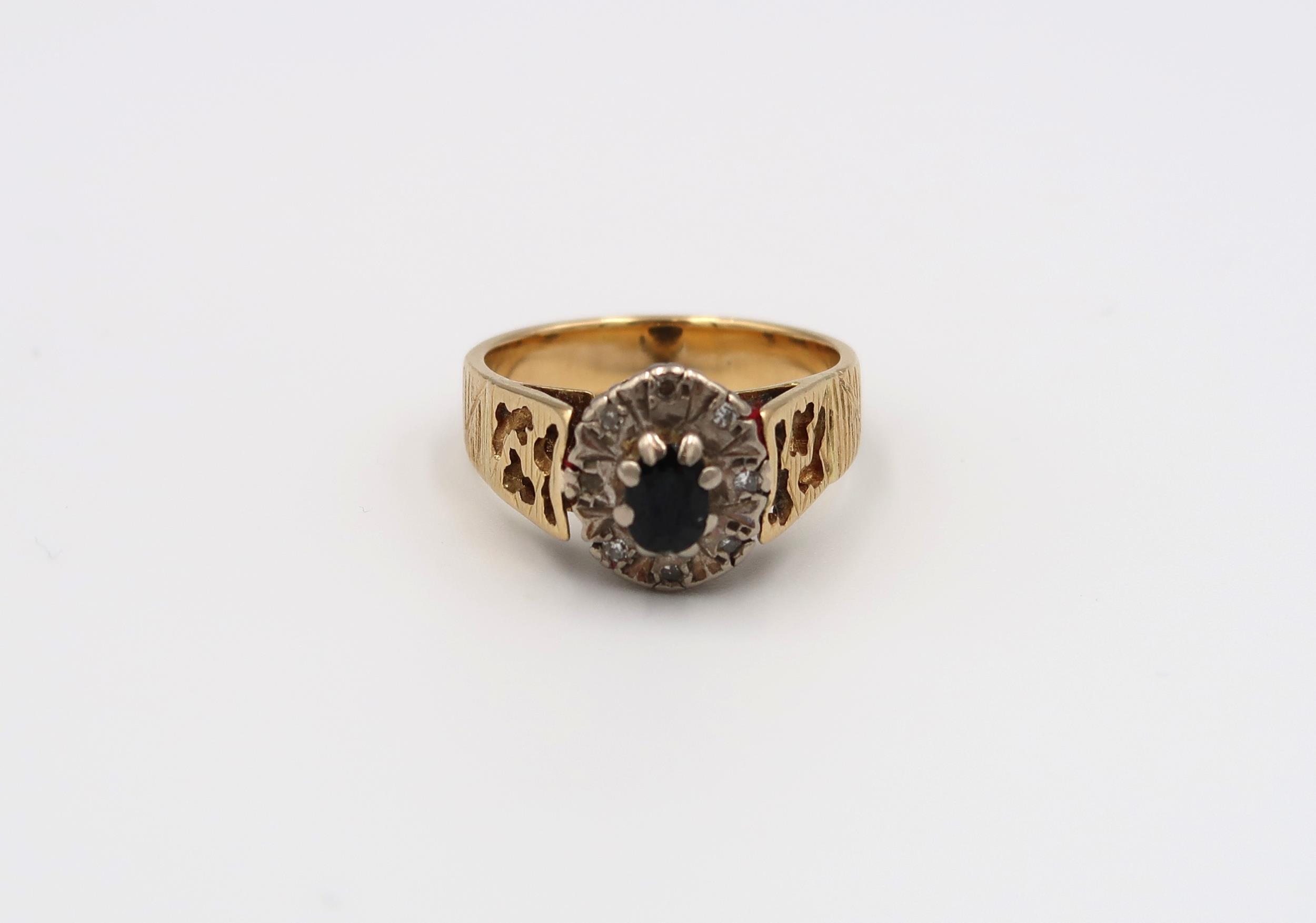 A Poss 18ct yellow and white gold dress ring with oval cut sapphire surrounded by 8 small old cut
