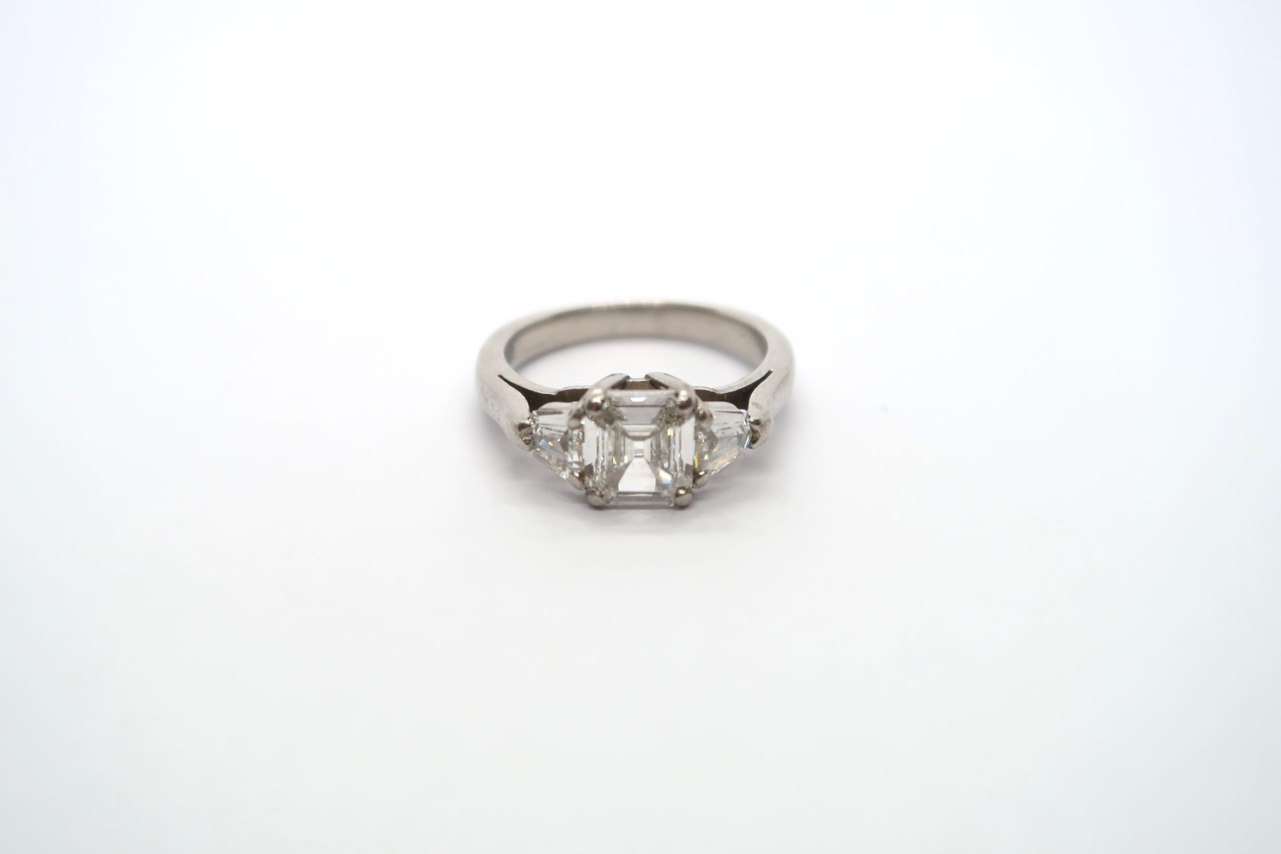 A very good platinum three stone diamond ring - The square emerald cut diamond estimated 1.1ct