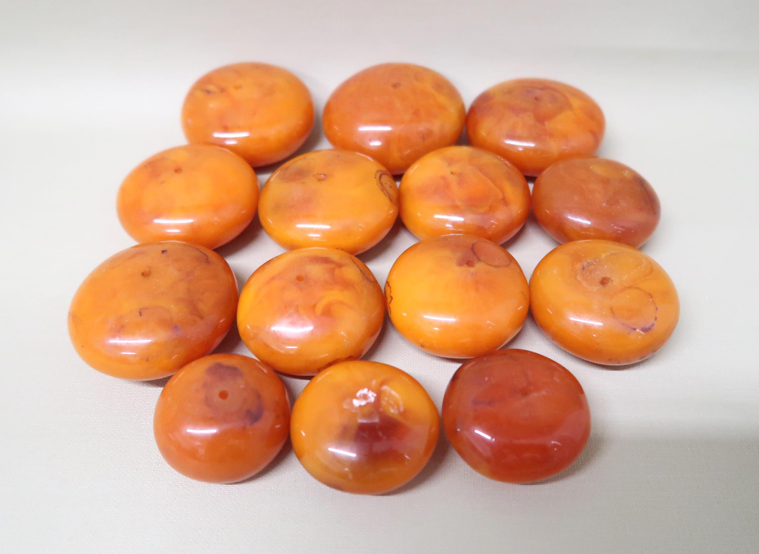 A graduated set of 14 butterscotch Amber beads of circular form ranging from 3.2cm x 2cm to 6cm x