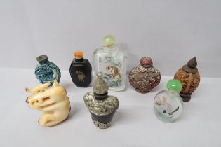Seven Oriental design perfume bottles, one glass decorated with a tiger amongst foliage with