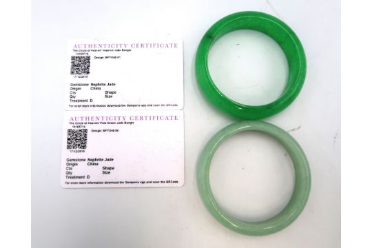 Two dyed green nephrite jade bangles. Approximate outer diameter 75mm.