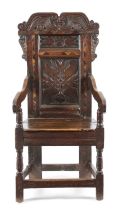 A CHARLES II OAK ARMCHAIR YORKSHIRE, C.1670-80 the scroll crest above a panelled back decorated with