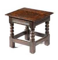 A CHARLES II OAK LOW STOOL C.1670-80 the moulded frieze above bobbin turned supports 40cm high, 43.