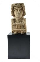 A Mexico carved stone deity possibly Chalchiuhticue with remains of pigment, 53.5cm high, on a