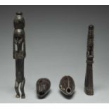 A Korwar float / charm Irian Jaya, Indonesia carved with a seated figure and with an open base,