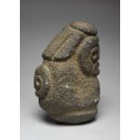 A Costa Rican stylised figure stone, wearing a headdress and with a relief mask to the back, 35cm